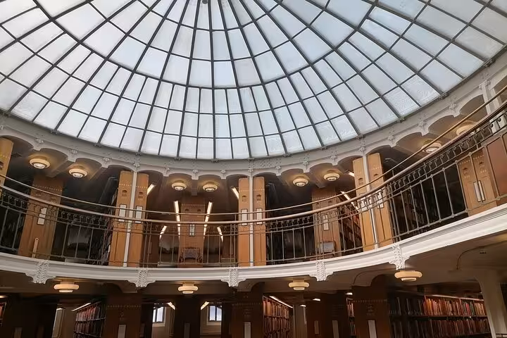 Brightly lit Helsinki library with a grand glass dome roof, highlighting its architectural beauty and cultural significance.