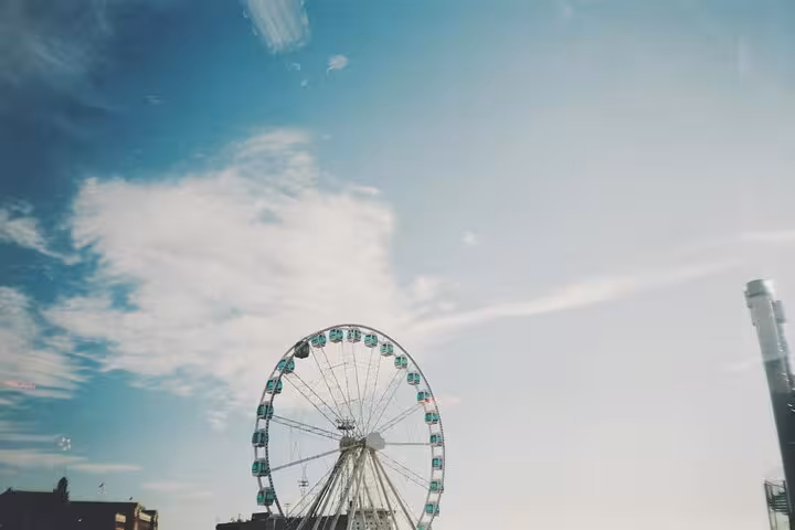 Experience the iconic Helsinki SkyWheel on a sociologist-led walking tour under a vibrant blue sky.