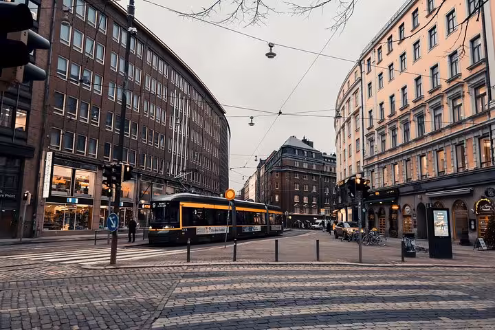 Iconic Helsinki tram passing through the bustling city center, a key sight on the sociologist-guided walking tour.