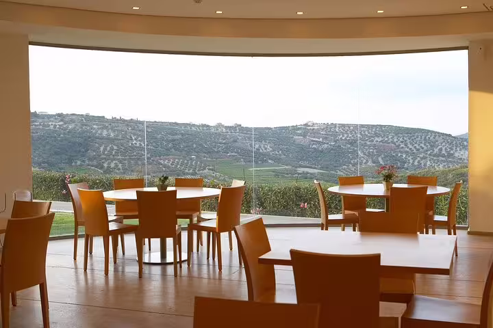 Modern dining area with panoramic views of Crete's lush vineyards near Knossos Palace, ideal for wine tasting tours.