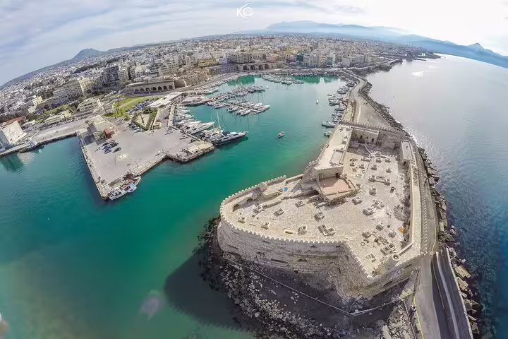 Aerial view of Heraklion's Venetian harbor and fortress, highlighting scenic coastal beauty and historic architecture.