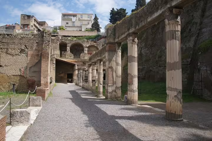 Ancient colonnade walkway at Herculaneum archaeological site on an affordable guided tour from Naples
