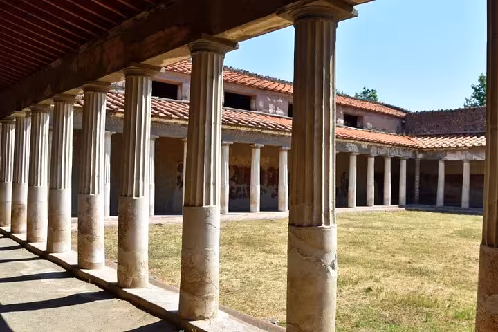 Explore ancient architecture with columns and courtyard on a Herculaneum half-day tour from Naples.