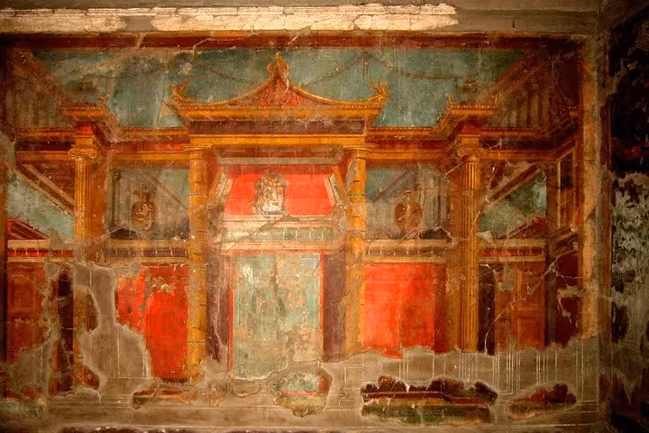 Colorful fresco depicting grand architecture in Oplontis ruins, highlighting rich Roman history and heritage.