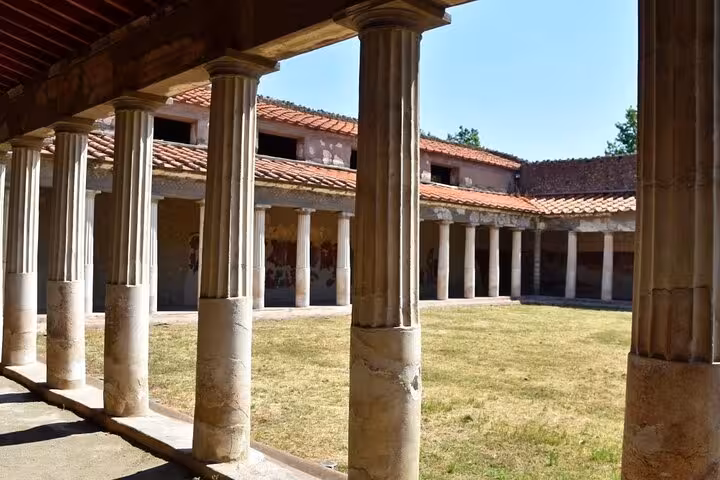 Impressive Roman columns in a courtyard at Herculaneum, part of a skip-the-line tour from Amalfi and Positano.