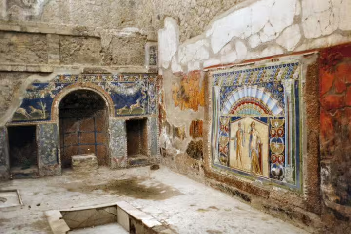 Colorful Roman frescoes and mosaic wall inside Herculaneum ruins, must-see stop on Naples day tour