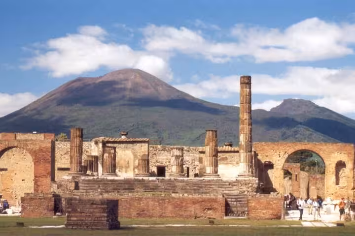 Ruins of ancient columns at Herculaneum with Mount Vesuvius in the background for skip-the-line tour package.