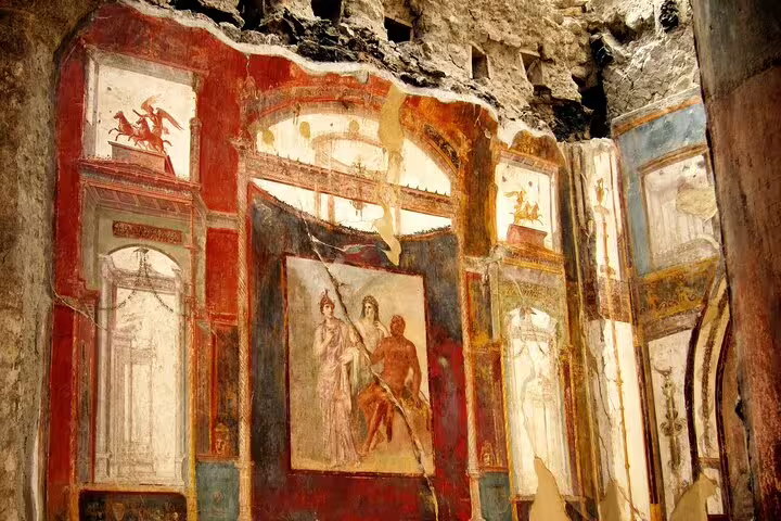 Vivid mythological frescoes on the walls of a Herculaneum villa, discovered during a private archaeological tour