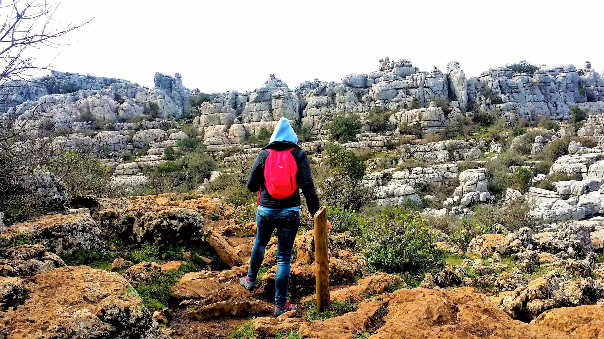 Hiker with red backpack on El Torcal trail, exploring karst limestone rocks on private trip from Costa del Sol