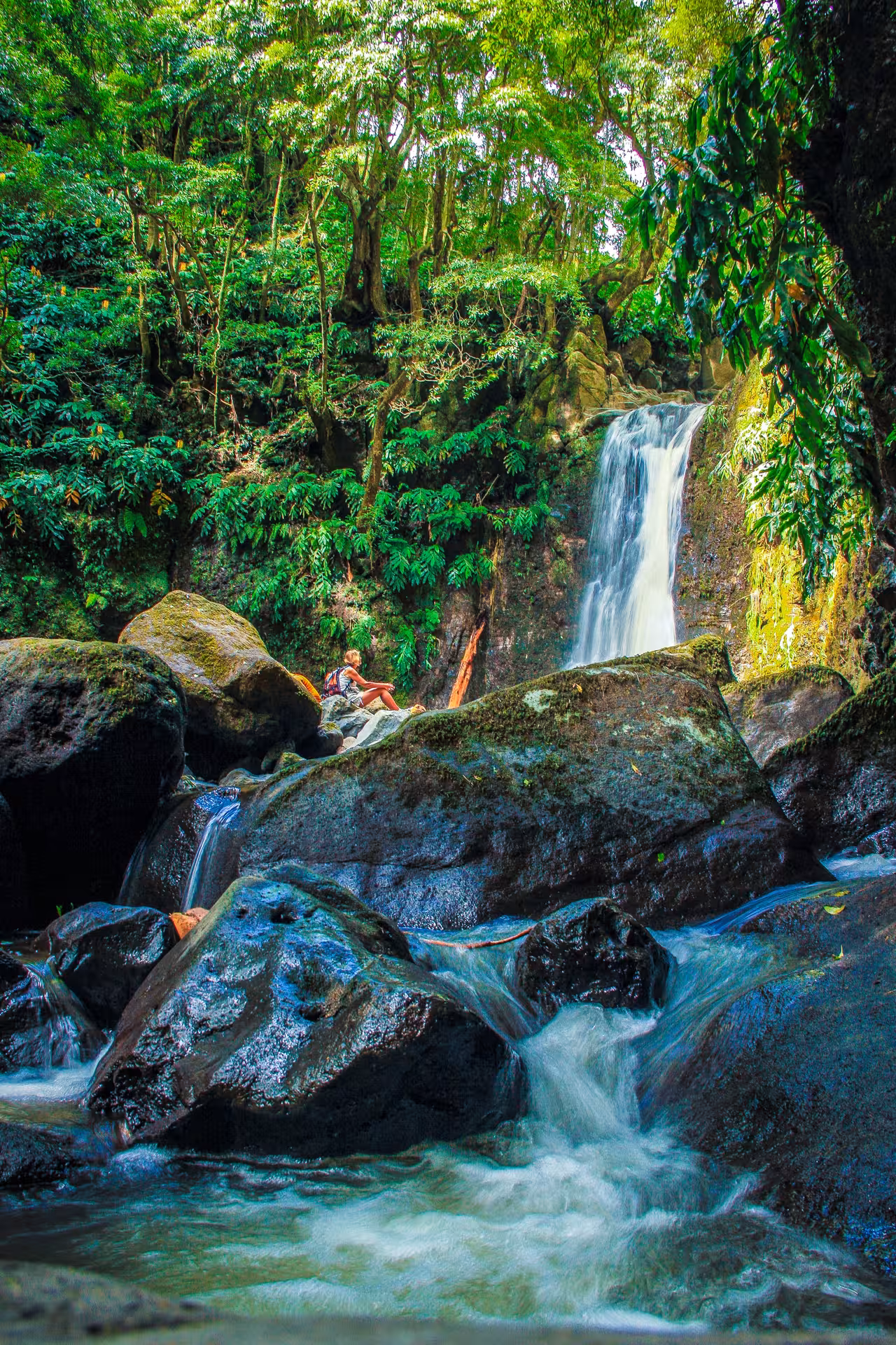 Hiker resting by Salto do Prego waterfall and stream on the HIKE Salto do Prego - Sanguinho tour, São Miguel