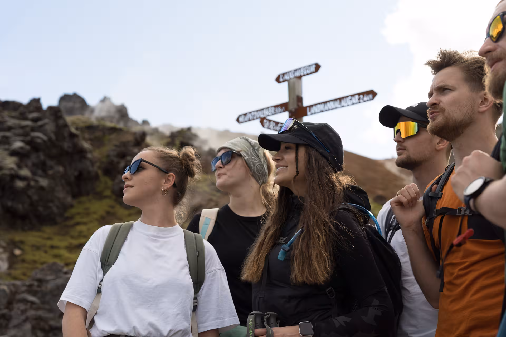 Hikers at Landmannalaugar trail signpost in Iceland Highlands, ready for guided trekking adventure tour