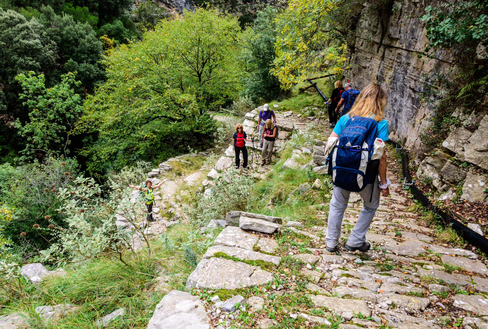 Hikers descending stone steps along the Ridomo Gorge trail, guided trekking in Taygetos mountains near Kardamyli