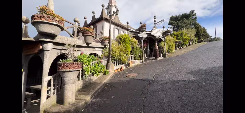 Charming hillside chapel with ornate stone architecture on the holy wine tour, surrounded by lush greenery.
