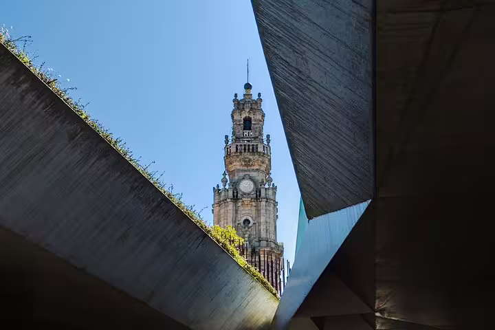 View of historic clock tower framed by modern architecture on a sunny day during a private tuk tuk tour in the city center.