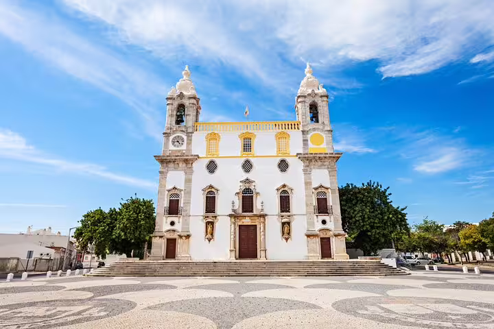 Historic Faro church under a vibrant blue sky, perfect for a quick and private 2-hour city tour experience.