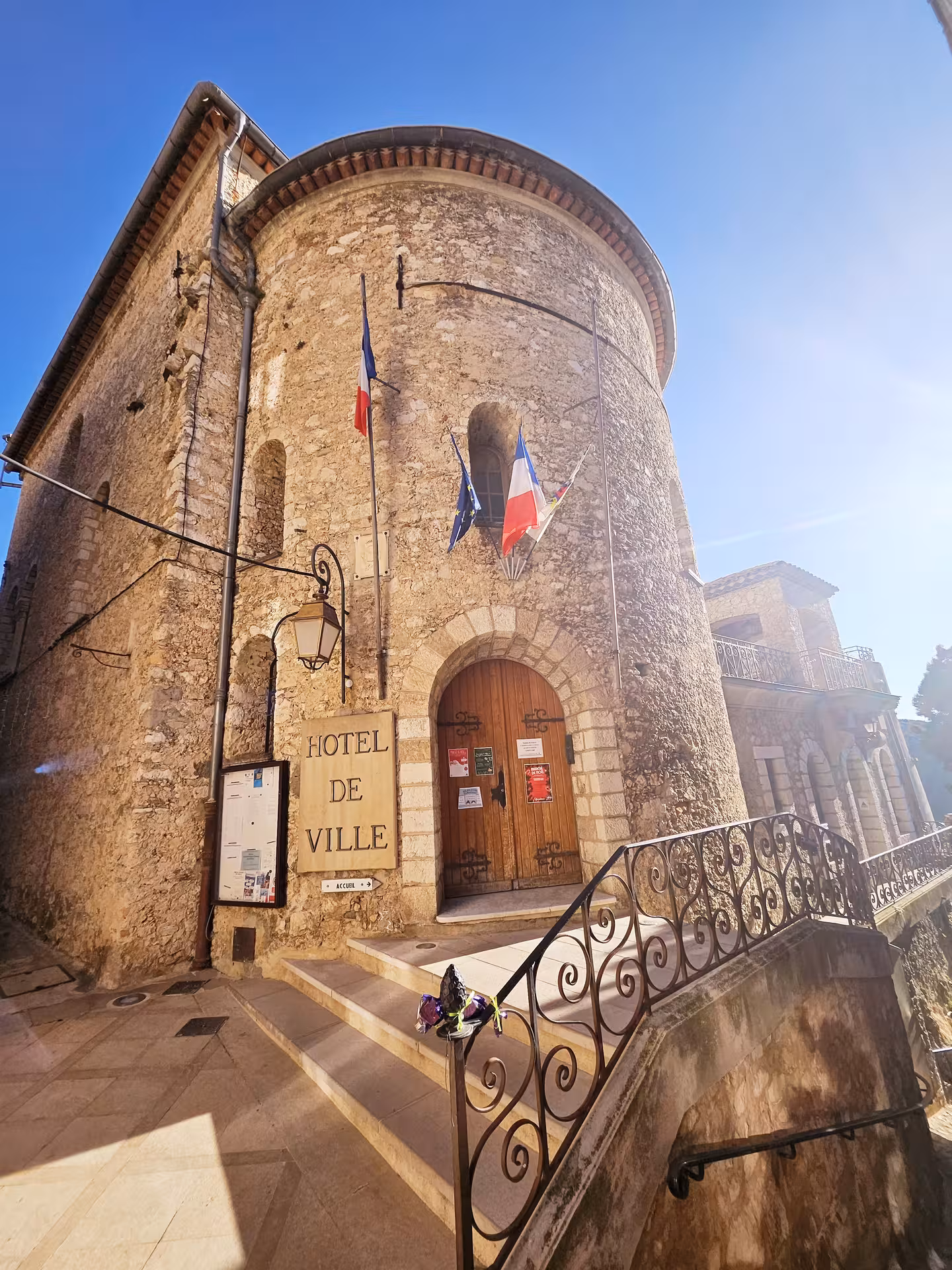 Historic Hôtel de Ville with rustic stone architecture in a sunlit East Côte d'Azur hilltop village.
