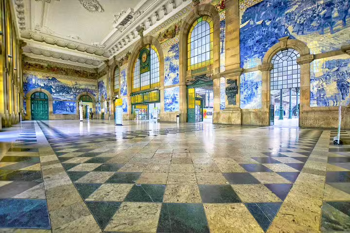 Colorful historic train station interior with ornate blue tile murals and arched windows, featured in private Tuk Tuk tour.