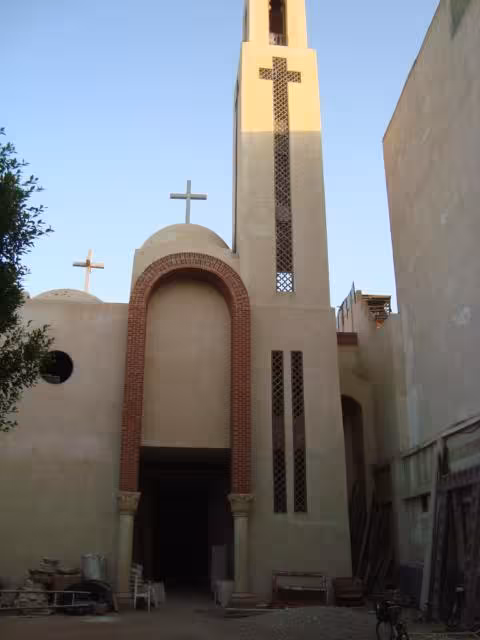 Church façade with tall bell tower and crosses, visited on The Holy Family Trip Christian tour in Egypt