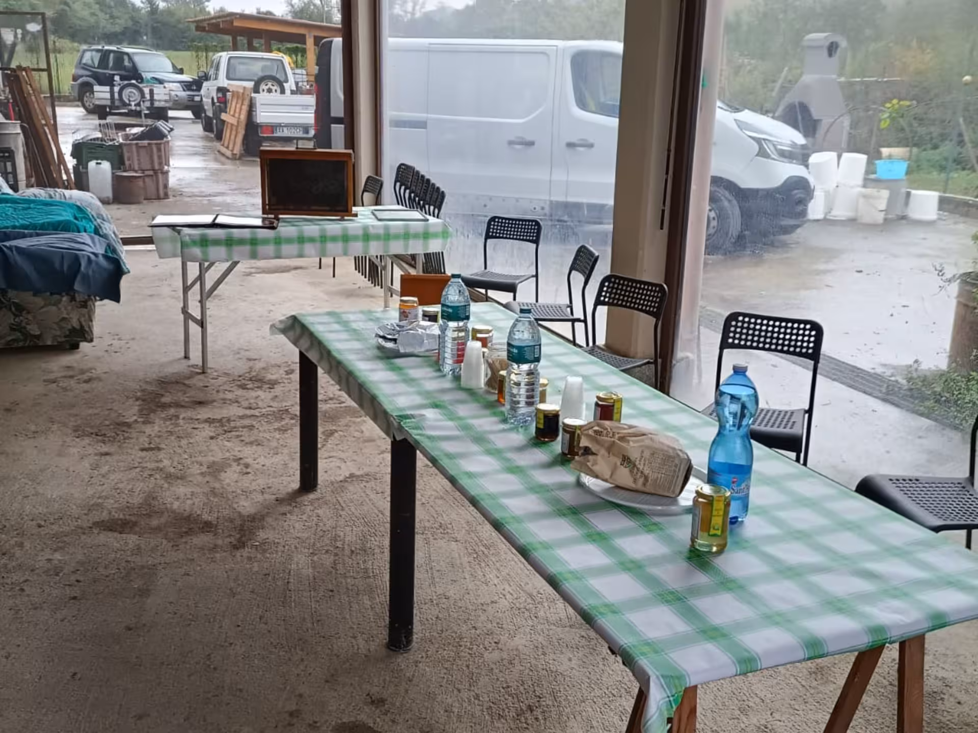 Empty tasting setup with honey jars and bottles on tables in a rustic Monferrato setting ready for visitors.