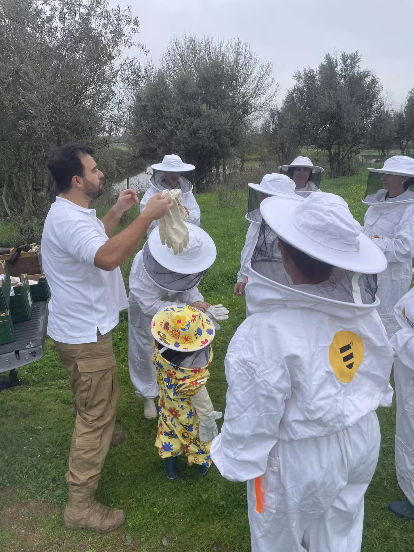 Group of participants, including a child in colorful gear, prepares for the hive tour in Montemor-o-Novo.