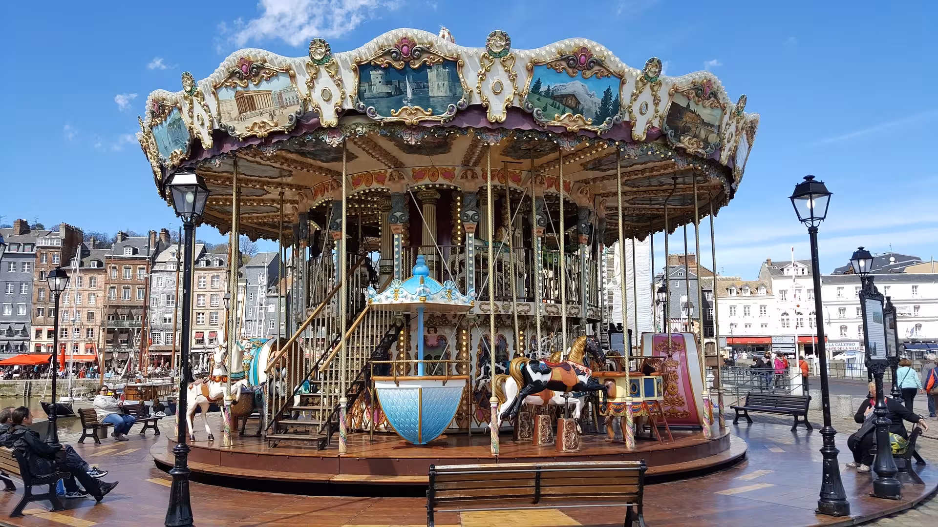 Vintage carousel on Honfleur harbor square near Vieux Bassin, a charming stop on a private guided e-bike tour