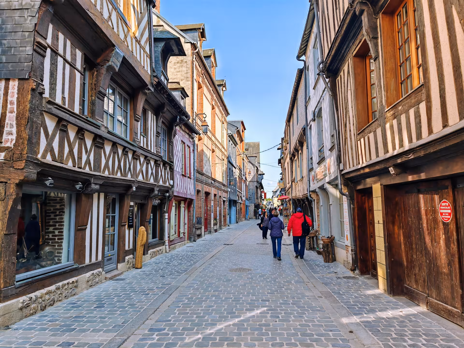 Cobblestone lane lined with half-timbered houses in Honfleur, explored on a private guided e-bike tour