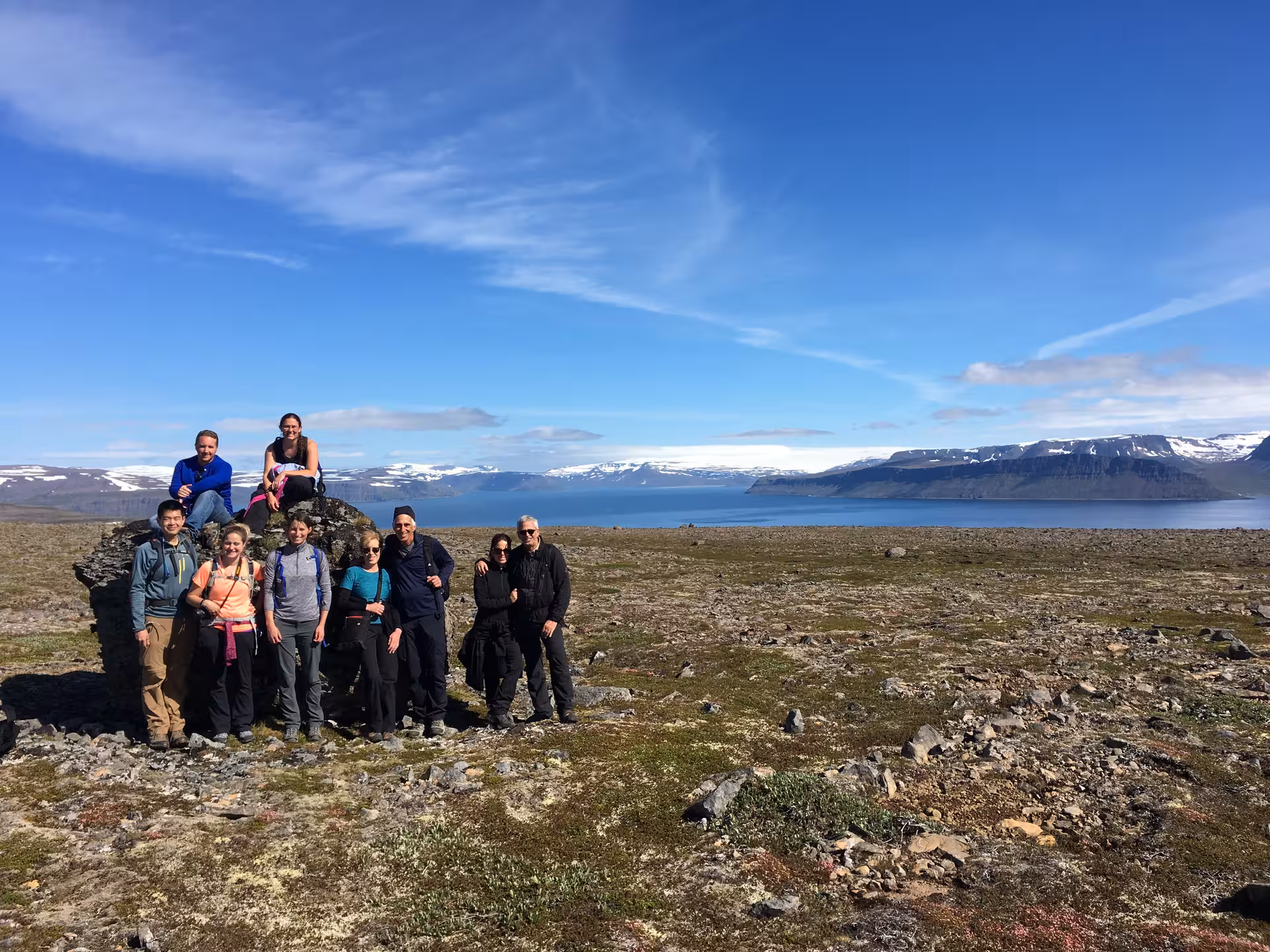 Group photo on Hornstrandir plateau with fjord and snowy peaks, Westfjords Iceland guided hiking adventure