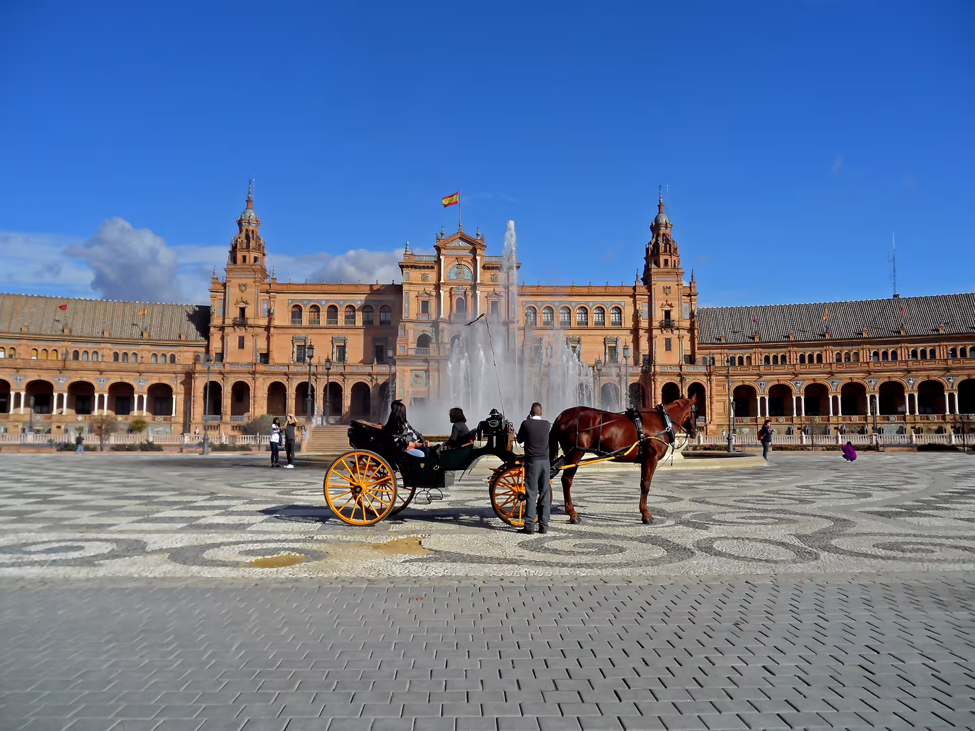 Horse-drawn carriage in front of Plaza de España fountain, Seville, on a sunny day, ideal for small group walking tours.