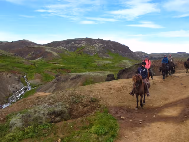 Horseback riders on Iceland highland trail near hot springs valley and waterfall on 05A Hot Springs Tour