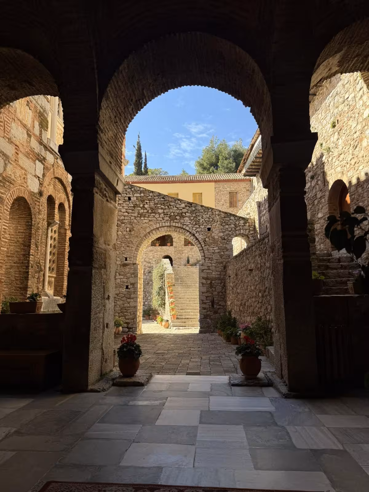 Stone archway corridor at Hosios Loukas Monastery courtyard on a private Delphi and Arachova day trip
