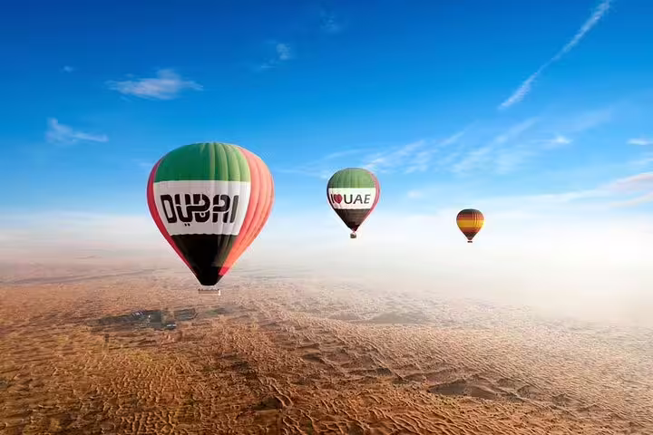 Hot air balloons soar over Dubai's desert landscape during a stunning morning tour, offering breathtaking views and adventure.
