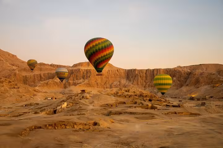 Sunrise hot air balloon ride over Luxor West Bank desert cliffs with hotel pickup and drop-off included