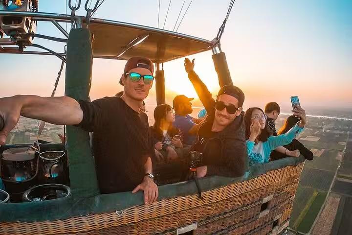 Travelers in a hot air balloon basket at sunrise over Luxor, unforgettable add-on to Sharm El Sheikh tour