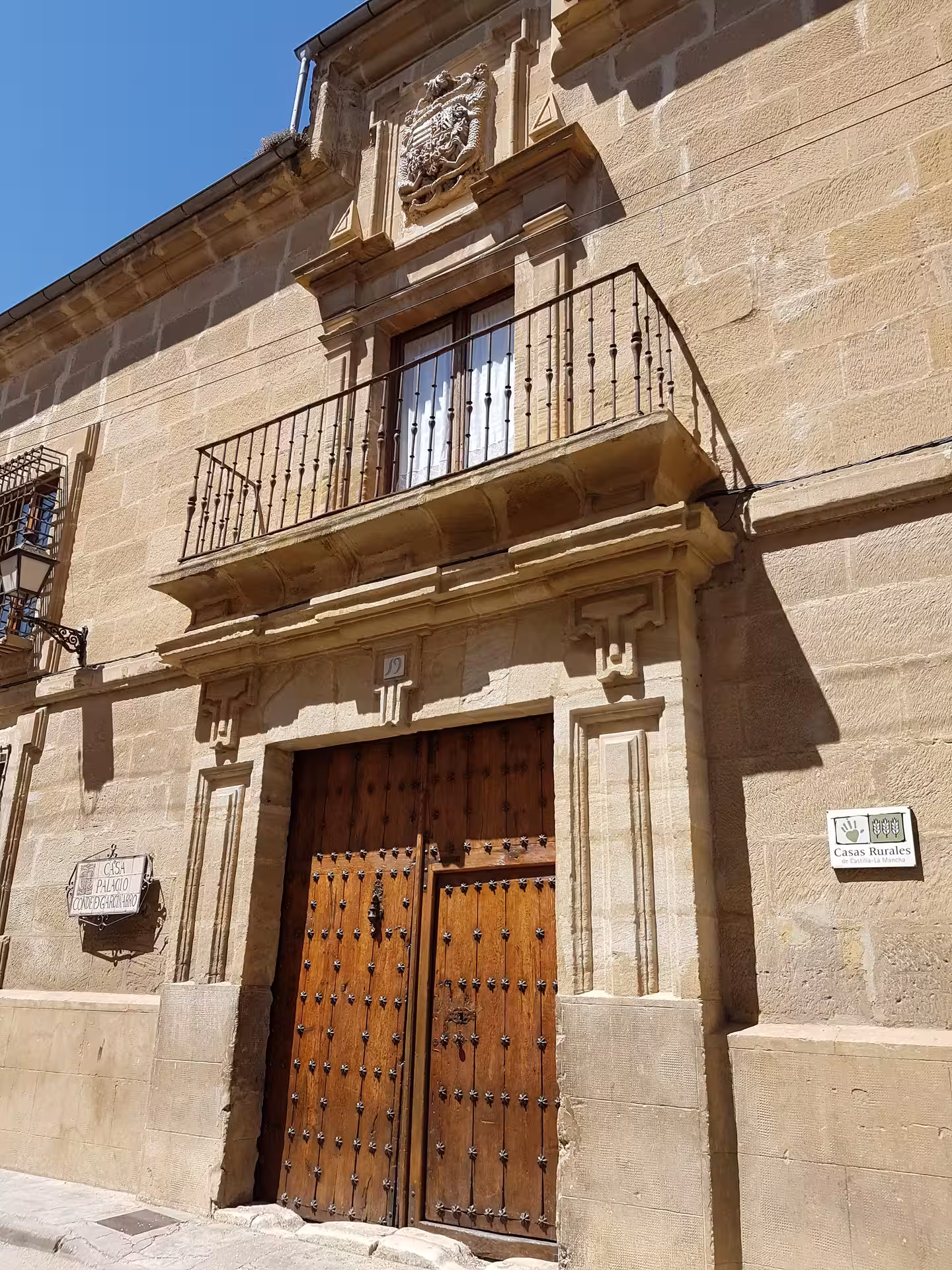 Historic Casa Rural facade with carved stonework and studded wooden door on Huete Monumental guided tour