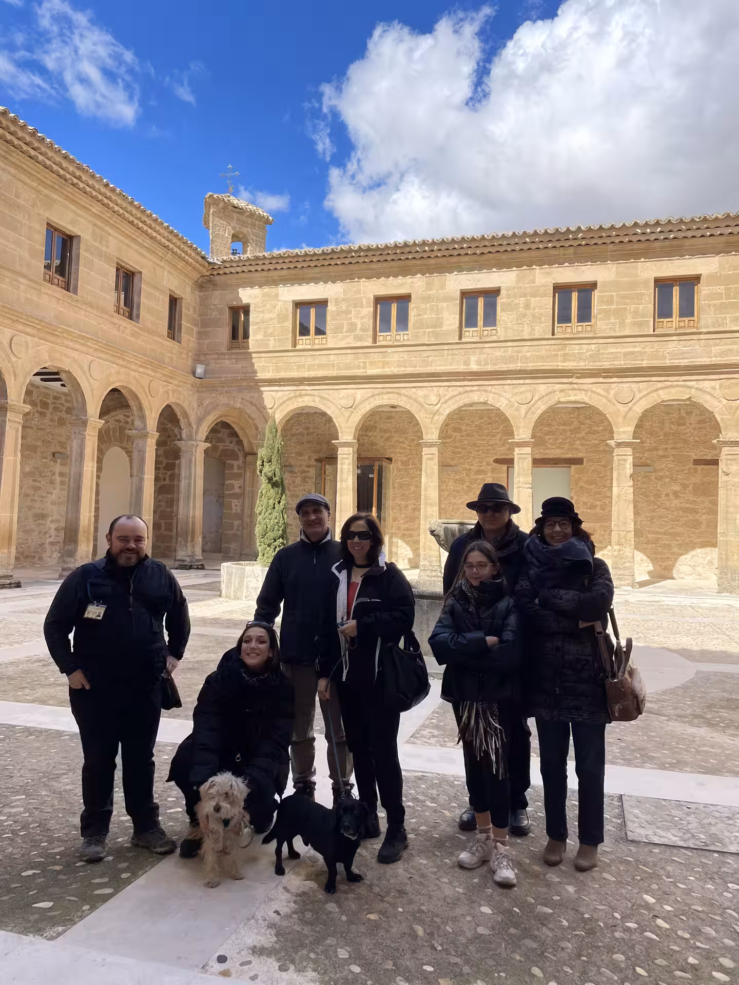Visitors pose in a historic stone cloister courtyard on the Guided tour of Huete Monumental, Cuenca