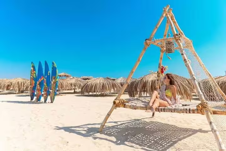 Beach hammock swing and palm huts on Hula Hula Island, part of VIP boat snorkeling day trip from Hurghada
