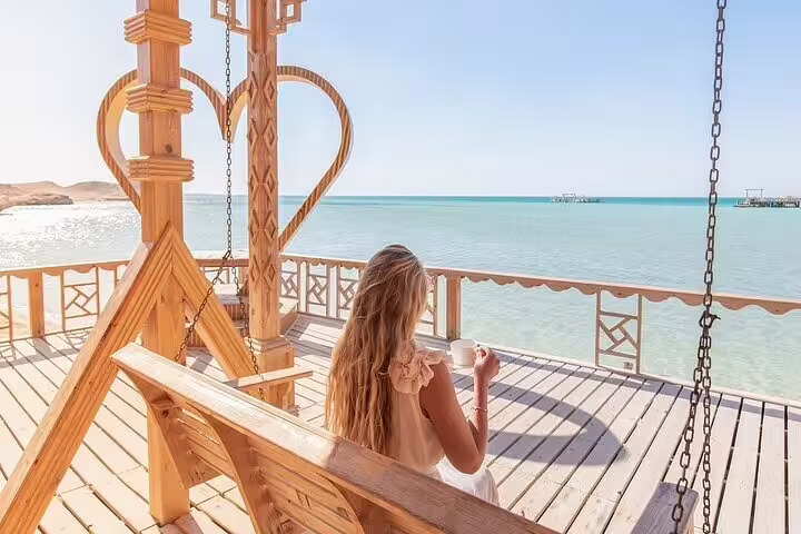 Relaxing on a wooden swing deck at Hula Hula Island, Red Sea, on a VIP snorkeling day trip from Hurghada