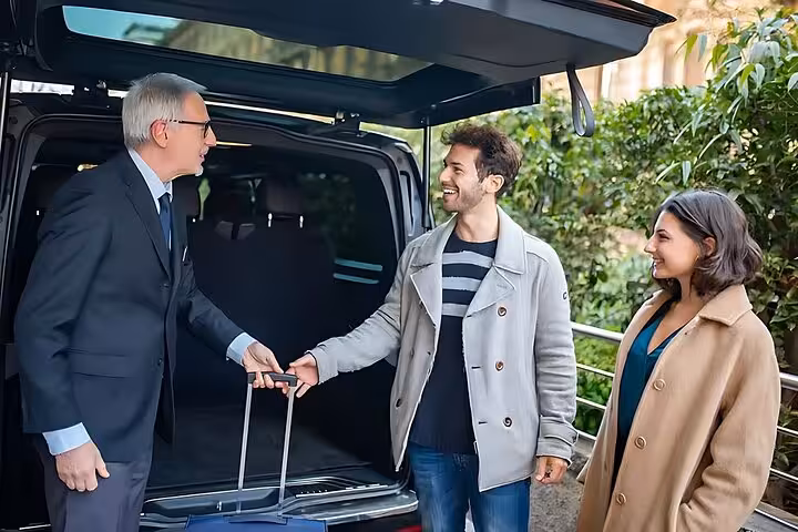 Friendly chauffeur greets couple by van with luggage, Hurghada airport private transfer fast comfortable pickup