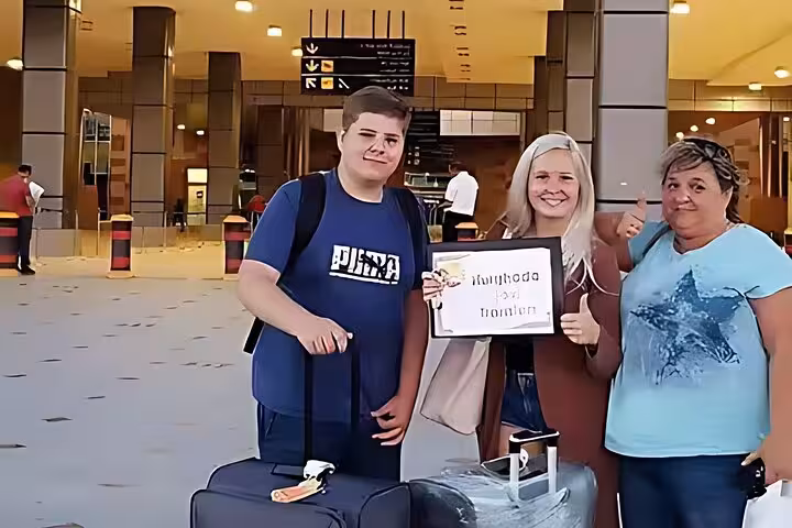 Travelers with suitcases at terminal meeting driver for Hurghada airport private transfer, fast comfortable ride