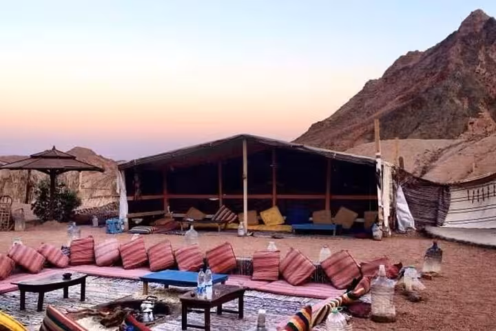 Bedouin desert camp lounge stop on Hurghada ATV quad safari and camel ride tour at sunset in Egypt