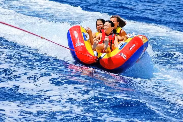Hurghada banana boat ride on the Red Sea, friends in life jackets on inflatable with private transfer included
