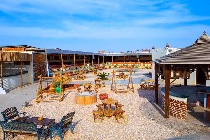 Bedouin village camp near Hurghada with rustic seating, ideal stop on jeep safari dinner and show tour