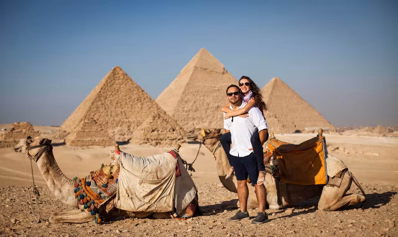 Tourists with camels in front of the Giza Pyramids on a Hurghada to Cairo day trip with guided sightseeing