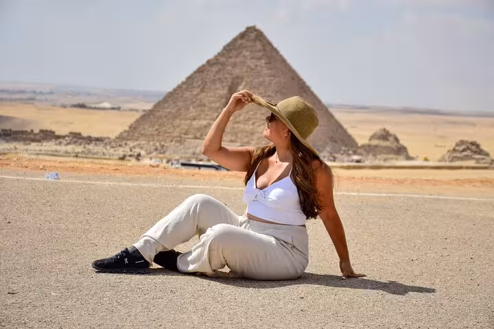 Traveler resting with Giza Pyramid backdrop on Hurghada to Cairo pyramids tour, scenic desert photo stop