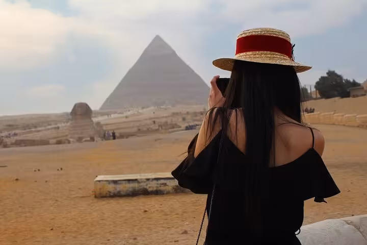 Traveler photographing the Great Pyramid of Giza on Hurghada to Cairo legacy trip including pyramids and GEM