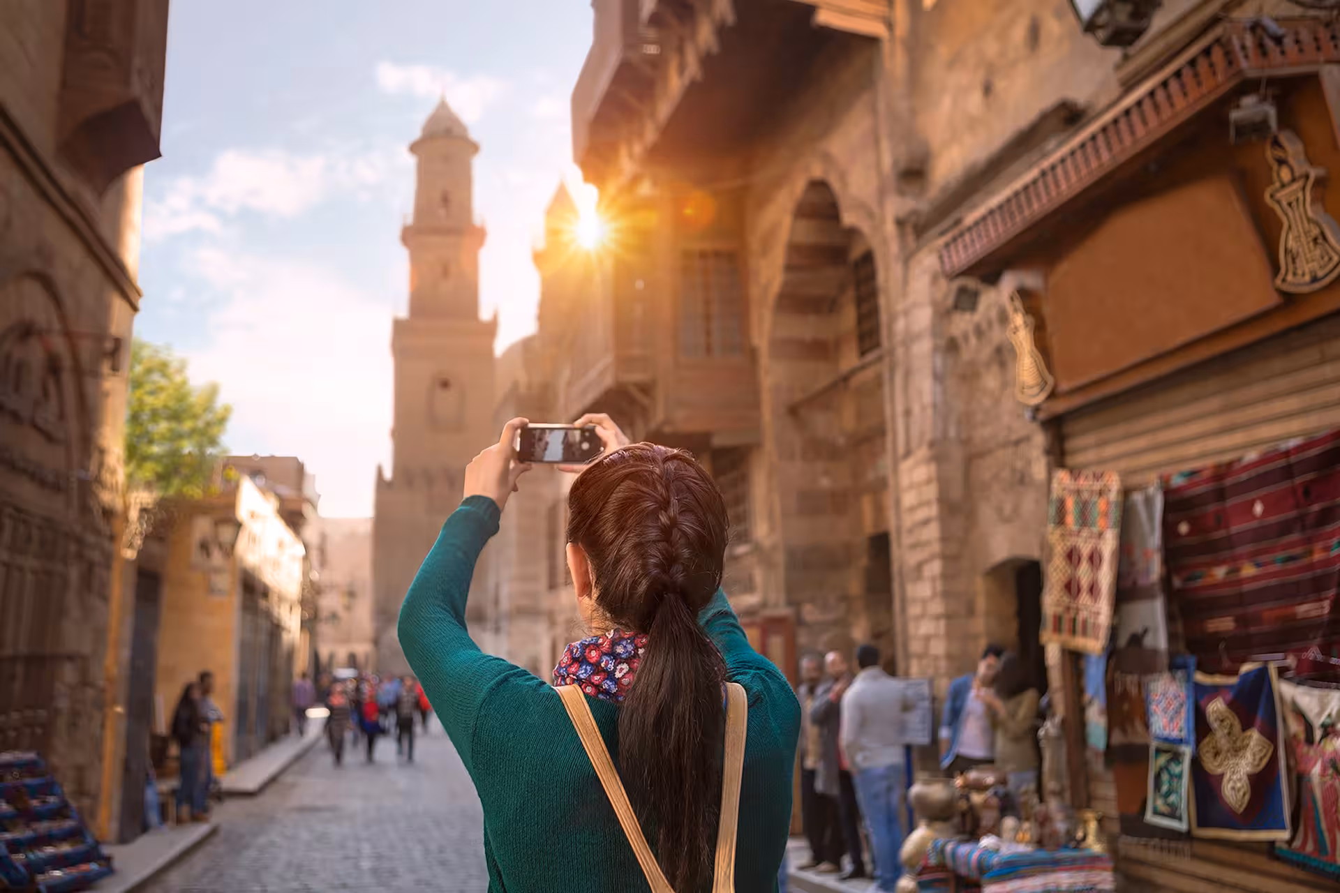 Traveler photographing Old Cairo street and minaret on Hurghada to Cairo tour with bazaar stop and guided sightseeing