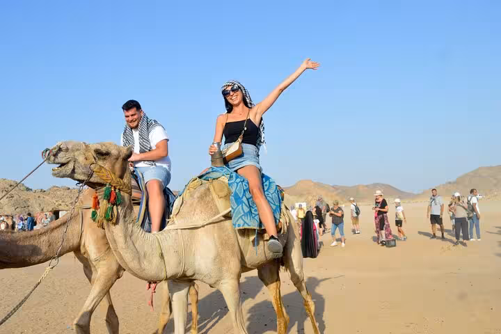 Tourists enjoying camel ride in Hurghada desert safari, part of 3-hour quad bike tour with free shopping