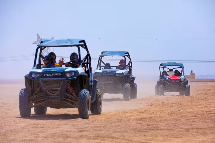 Polaris dune buggies racing in Hurghada desert safari, thrilling off-road ride before BBQ dinner and show