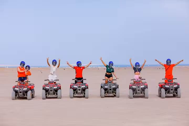 Group on quad bikes in Hurghada desert with helmets, celebrating on HRG family safari with dinner and shopping