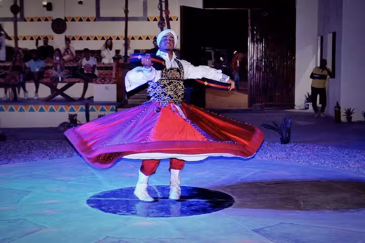 Tanoura dancer spinning at Bedouin camp show on Hurghada Jeep Super Safari with dinner under desert lights